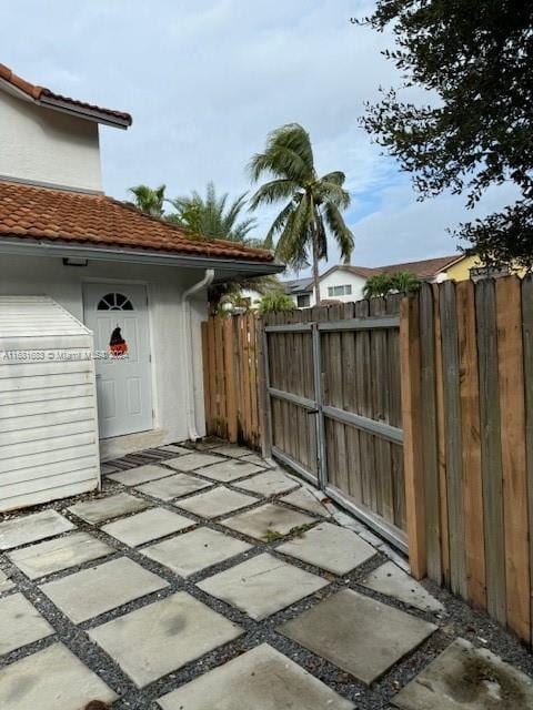 view of gate with a patio