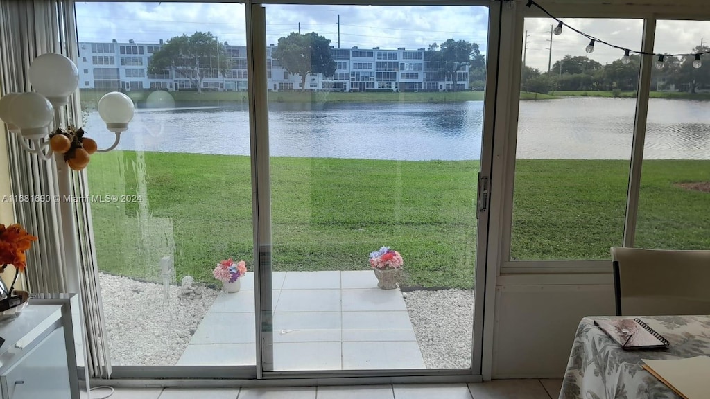 doorway featuring a water view and tile patterned flooring