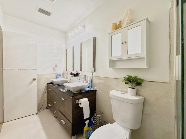 bathroom with tile walls, vanity, and toilet