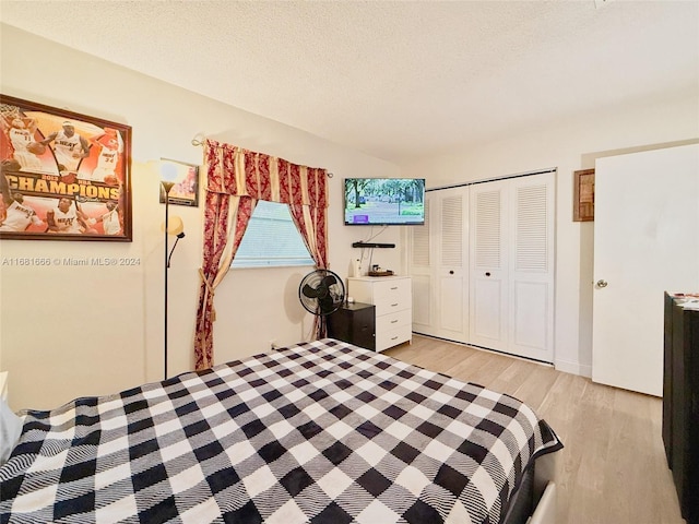 bedroom featuring a closet, a textured ceiling, and light hardwood / wood-style flooring