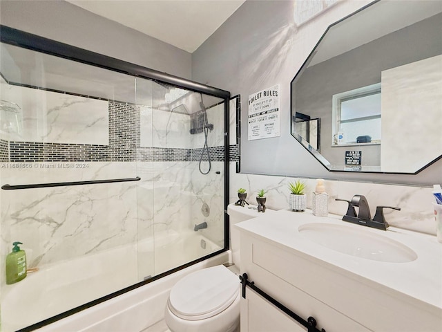 full bathroom with vanity, toilet, decorative backsplash, and enclosed tub / shower combo