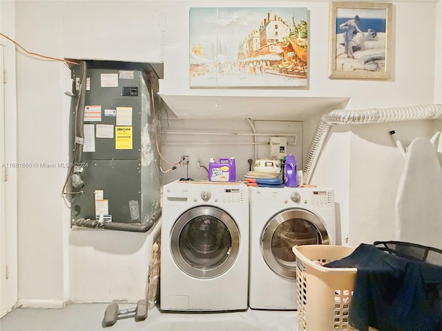 washroom featuring washing machine and dryer and heating unit