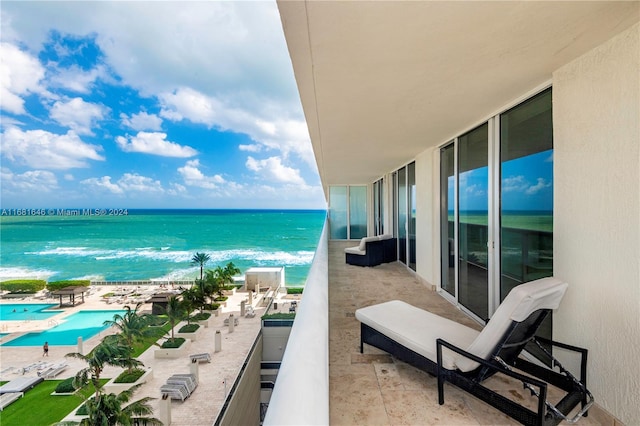 balcony featuring a beach view and a water view