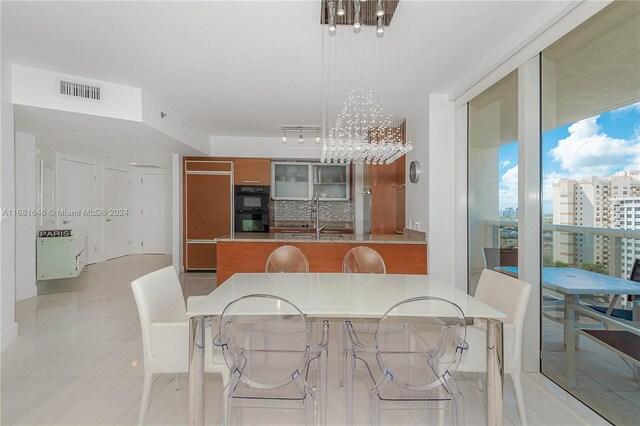 tiled dining area featuring sink and a chandelier