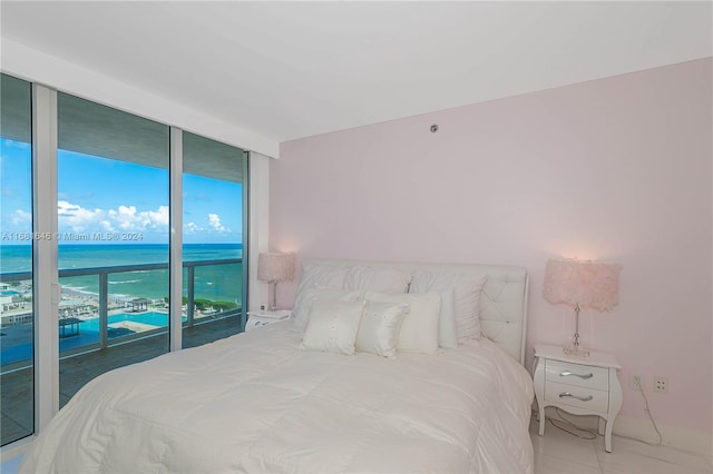 bedroom featuring a water view, floor to ceiling windows, multiple windows, and access to exterior