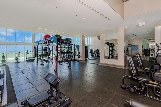 workout area featuring expansive windows and a water view