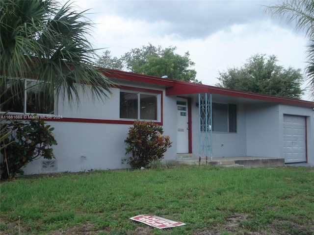 ranch-style home with a garage and a front lawn