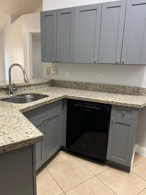 kitchen with kitchen peninsula, light stone counters, dishwasher, gray cabinets, and sink