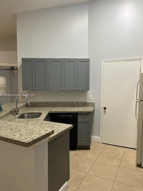 kitchen featuring gray cabinets, sink, light stone countertops, and light tile patterned floors