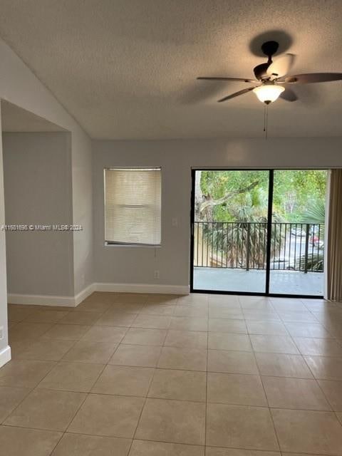 tiled empty room with a textured ceiling and ceiling fan