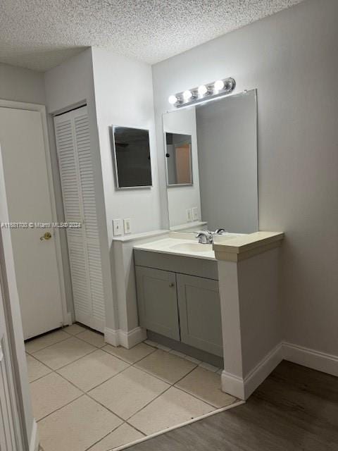 bathroom with vanity, a textured ceiling, and tile patterned flooring