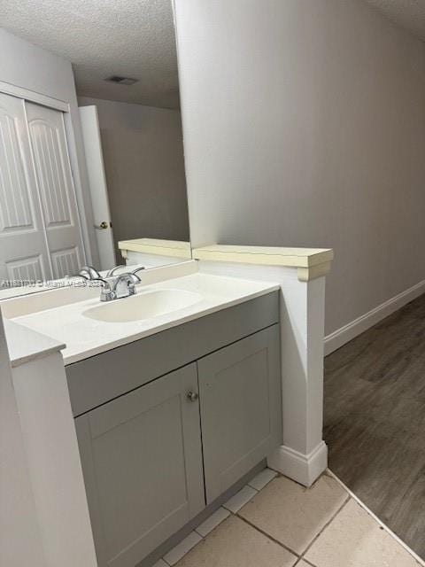 bathroom with vanity, hardwood / wood-style flooring, and a textured ceiling