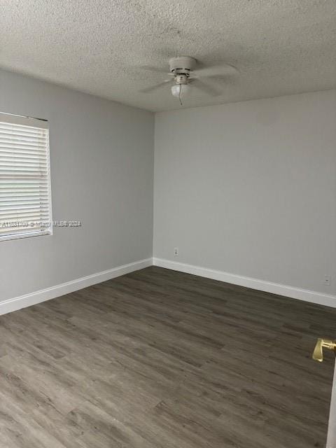 unfurnished room featuring a textured ceiling, dark hardwood / wood-style floors, and ceiling fan