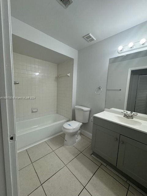 full bathroom with toilet, tiled shower / bath combo, vanity, and tile patterned floors