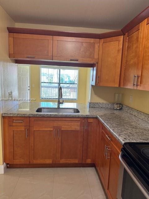10018 NW 4th St Unit 203, Pembroke Pines, FL 33024 - kitchen featuring light stone counters, brown cabinetry, and light tile patterned floors