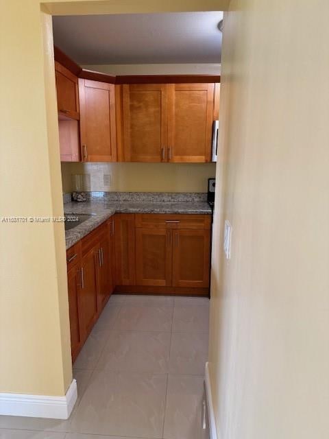 kitchen with light stone countertops and light tile patterned floors