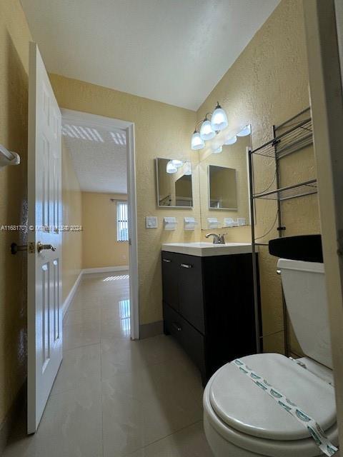 10018 NW 4th St Unit 203, Pembroke Pines, FL 33024 - bathroom featuring vanity, a textured wall, and tile patterned floors