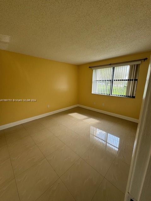 10018 NW 4th St Unit 203, Pembroke Pines, FL 33024 - unfurnished room with a textured ceiling and tile patterned flooring