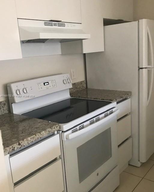 kitchen with white cabinets, white electric stove, dark stone counters, and light tile patterned floors