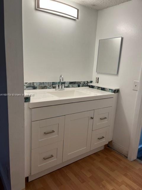 bathroom featuring vanity, wood-type flooring, and a textured ceiling