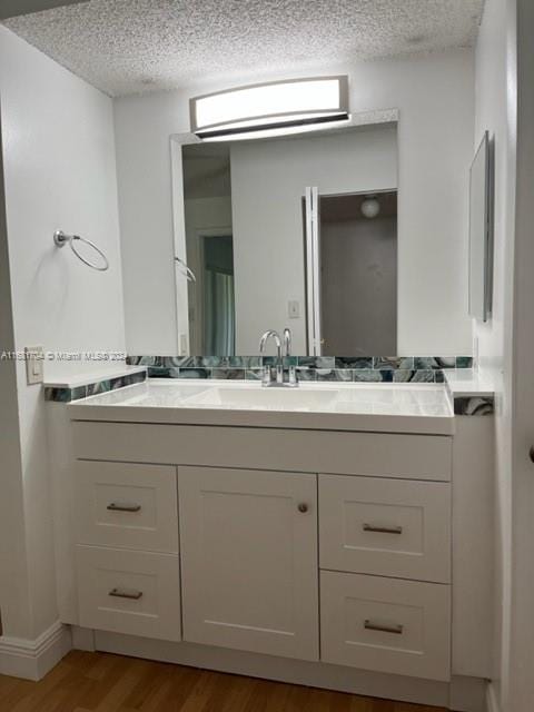 bathroom featuring vanity, a textured ceiling, and wood-type flooring