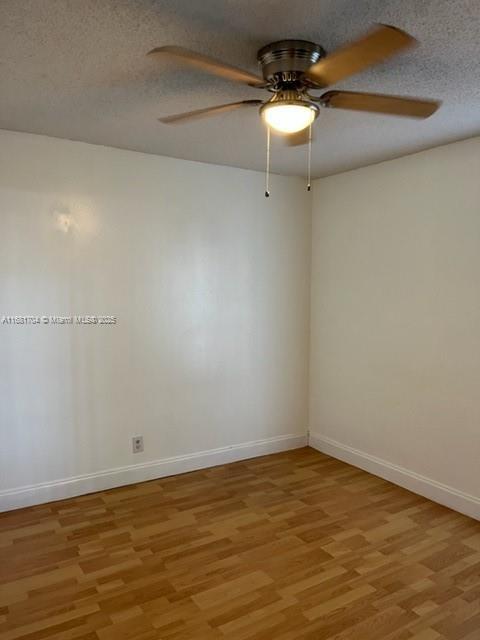 empty room with light hardwood / wood-style floors, a textured ceiling, and ceiling fan