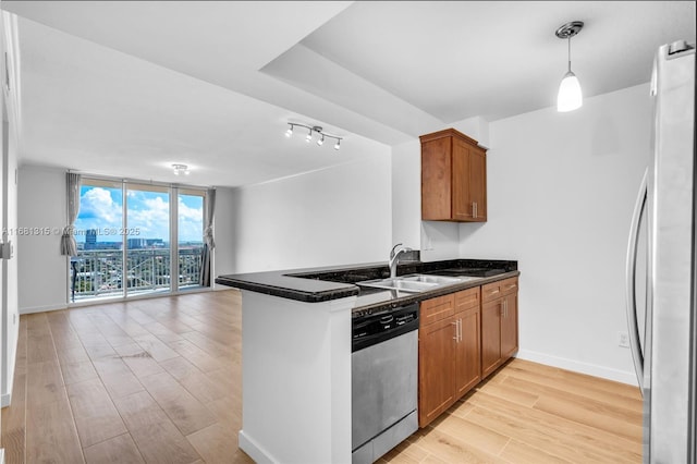 kitchen with brown cabinets, stainless steel appliances, open floor plan, a wall of windows, and a peninsula