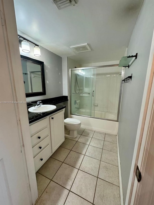 full bathroom featuring toilet, combined bath / shower with glass door, vanity, and tile patterned floors