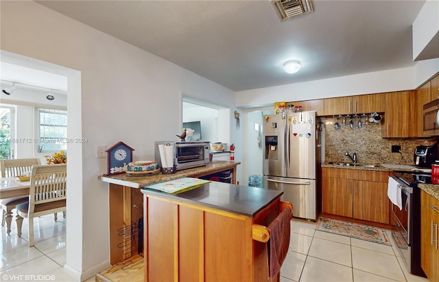 kitchen with light tile patterned floors, tasteful backsplash, appliances with stainless steel finishes, and sink