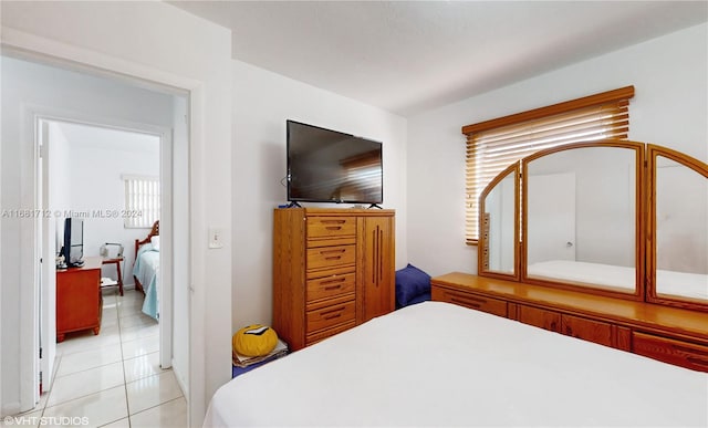 bedroom with multiple windows and light tile patterned floors