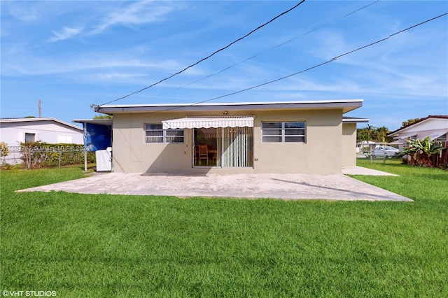 back of property featuring a patio and a lawn