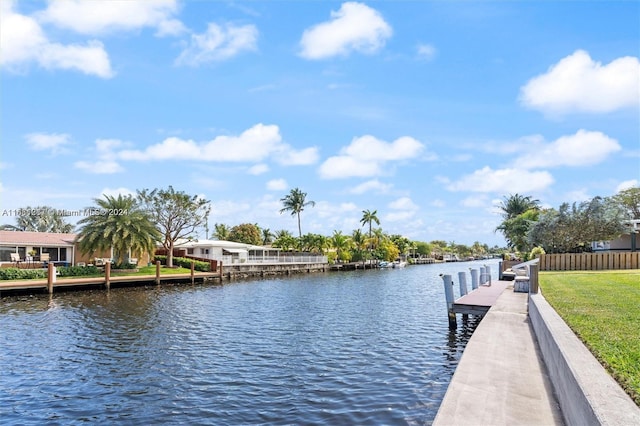 dock area with a water view and a yard