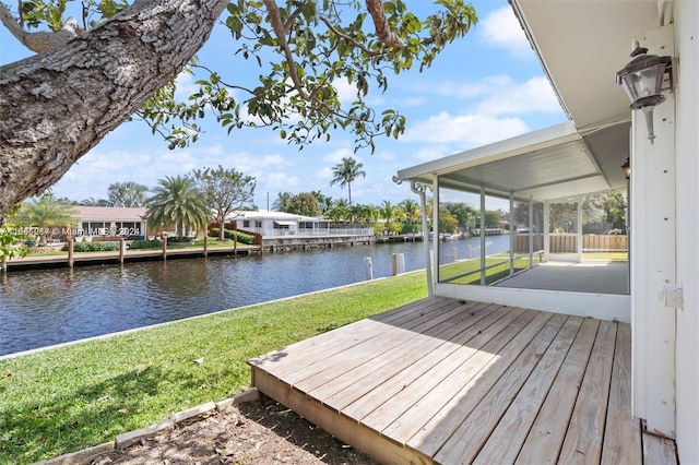 deck with a water view and a lawn