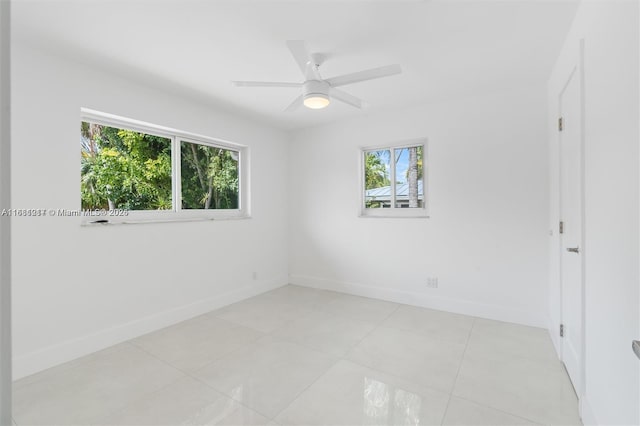 tiled spare room with plenty of natural light and ceiling fan