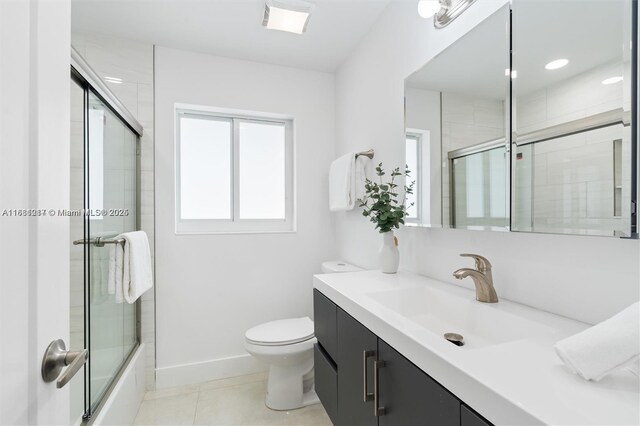 full bathroom with shower / bath combination with glass door, vanity, toilet, and tile patterned flooring