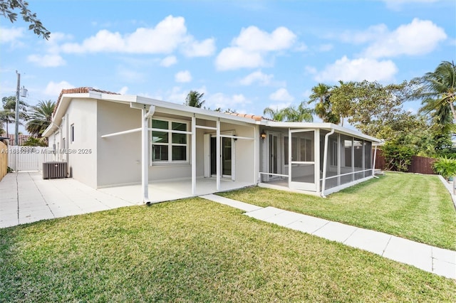 back of house featuring a patio, a sunroom, a yard, and central AC unit