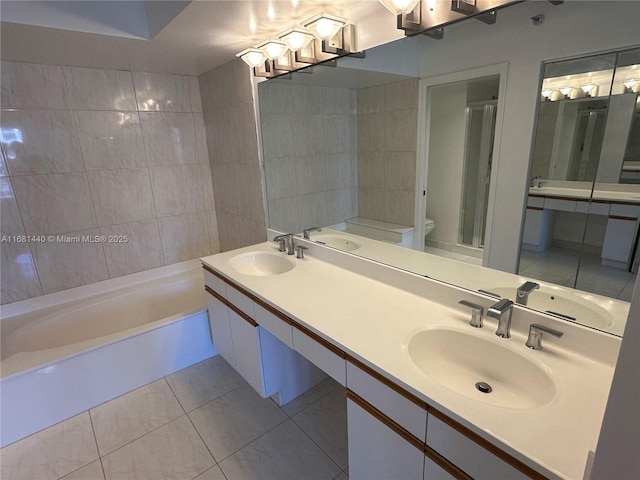 bathroom featuring a bathtub, tile patterned flooring, vanity, and toilet