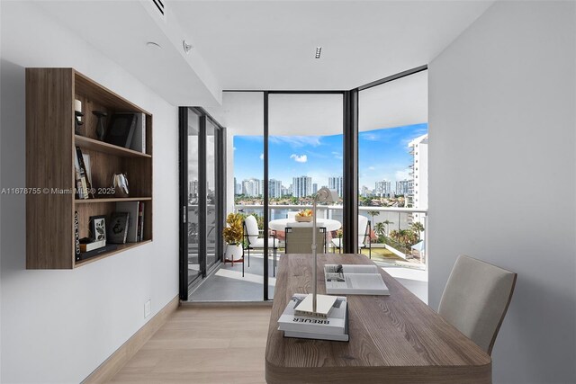 dining area featuring a wall of windows and light hardwood / wood-style flooring