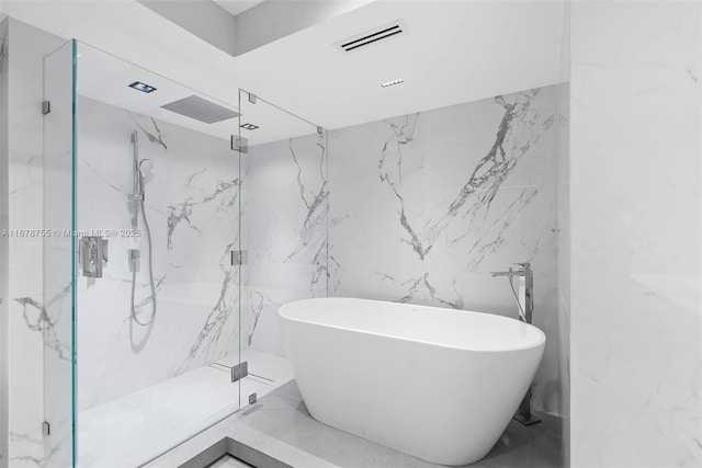 bathroom featuring tile walls and separate shower and tub