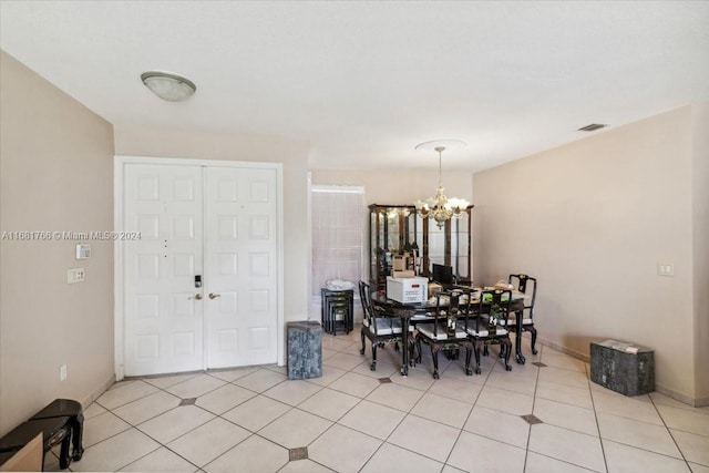 tiled dining space featuring an inviting chandelier