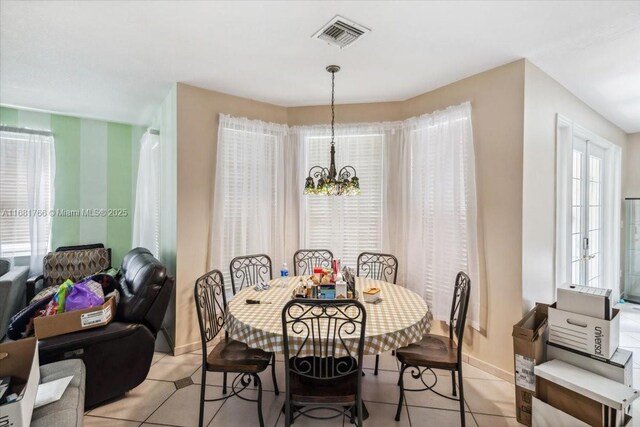 tiled dining room featuring a notable chandelier