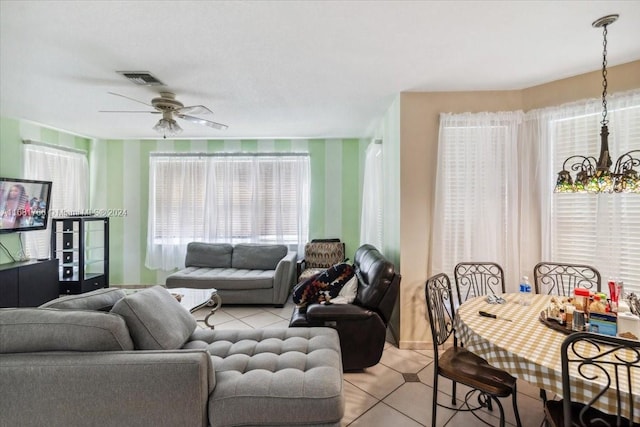 living room featuring ceiling fan with notable chandelier and light tile patterned floors