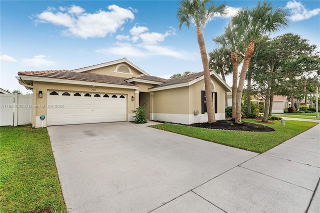 ranch-style home featuring a front lawn and a garage