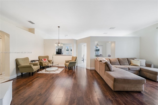 living room featuring dark wood-type flooring and a notable chandelier