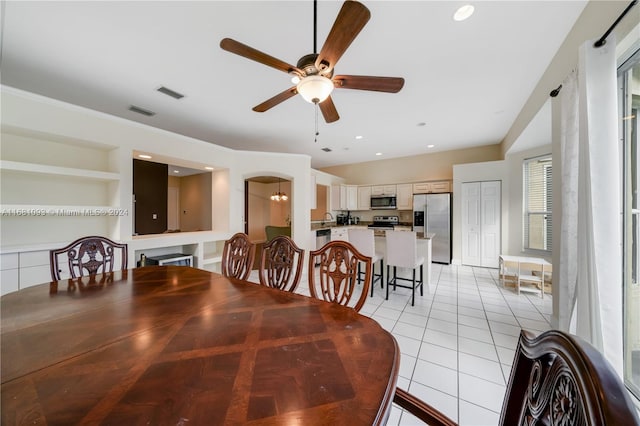 dining room featuring ceiling fan, light tile patterned floors, built in features, and a wealth of natural light