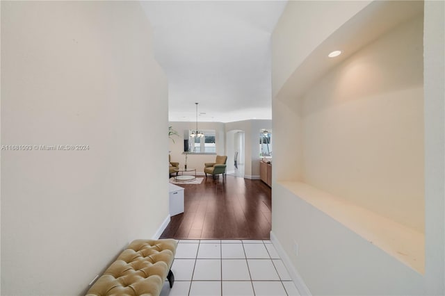 corridor featuring light hardwood / wood-style flooring and a notable chandelier