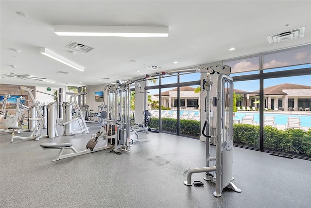 exercise room featuring a wall of windows, a wealth of natural light, and ceiling fan