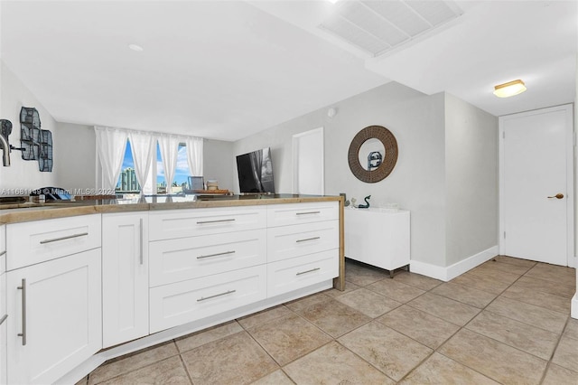 kitchen featuring white cabinetry and light tile patterned floors