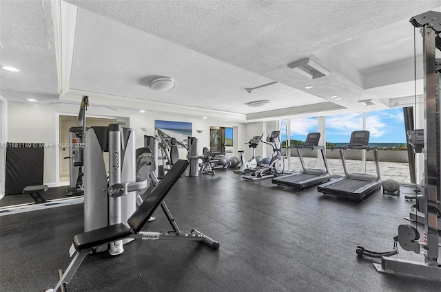 workout area featuring a textured ceiling and a raised ceiling