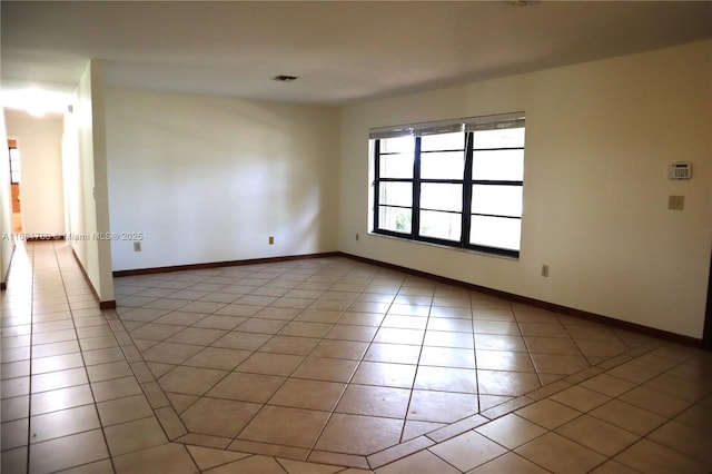 spare room with light tile patterned floors, baseboards, and visible vents